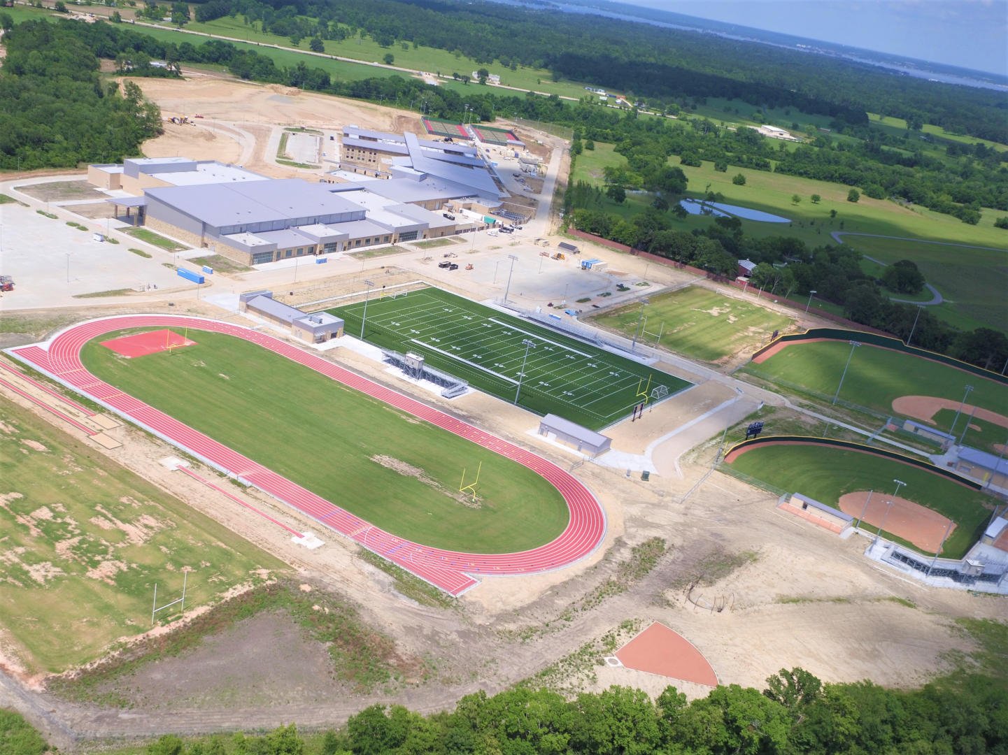 Montgomery ISD – Lake Creek High SchoolThe 130 acre site subdivided by a seasonal creek included such significant elevation variation that there was 20’ of cut/fill required to prepare a suitable building pad.  Additionally, expansive soils required a structural slab.  The impressive 382,000 SF structure is framed with conventional structural steel and utilizes a mixture of face brick, stone and metal panel veneer for exterior surface and features a standing seam roof on much of the building.  The building includes an auditorium with acoustical shell, multiple gymnasiums and food service facilities.  Interior finishes include terrazzo floors, LVT and ceramic tile.  Scope also includes competition baseball, softball and football fields, running track, tennis courts and greenhouses.Back to Portfolio